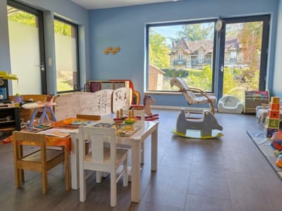 La pièce de vie ouverte sur le jardin : coin lecture, petits fauteuils et jeux à bascule
