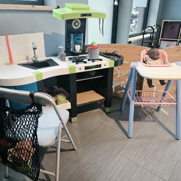 Coin dinette : petite cuisine et poupée dans sa chaise haute