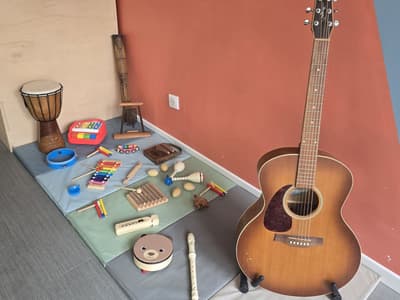 Instruments d'éveil musical posés sur les tapis : djembé, xylophones, kalimba, tambourins